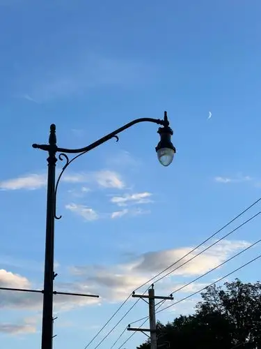 Streetlight dreams under a crescent moon.